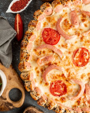 Sosisli pizza ve domates dilimleri.