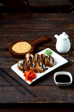 sushi rolls with soybean sauce ____