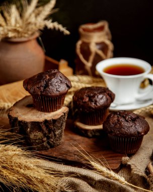 Üç çikolatalı kek ahşap tahtalarda kırsal tarzda servis ediliyor.