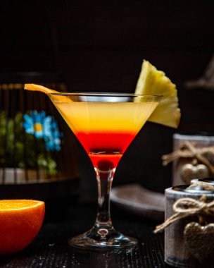 Portakallı ve ananaslı bir martini bardağı.