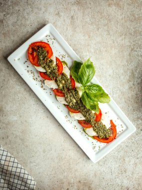 Dilimlenmiş beyaz peynir ve otlu domates.