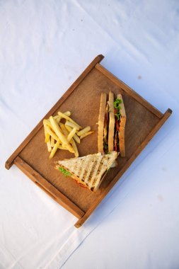 Tahtada patates kızartması olan kulüp sandviçi.