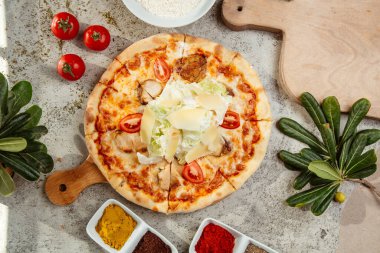 Üstü marul salatası ve parmesanlı hindi pizzası.
