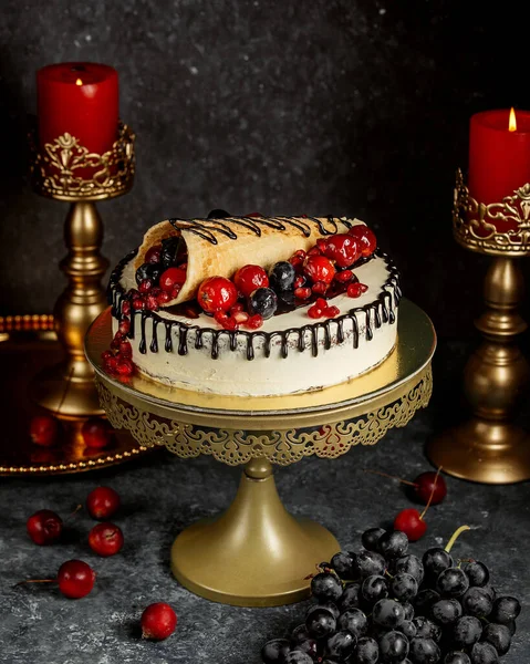 chocolate dripping cake garnished with wrapped waffle with berries