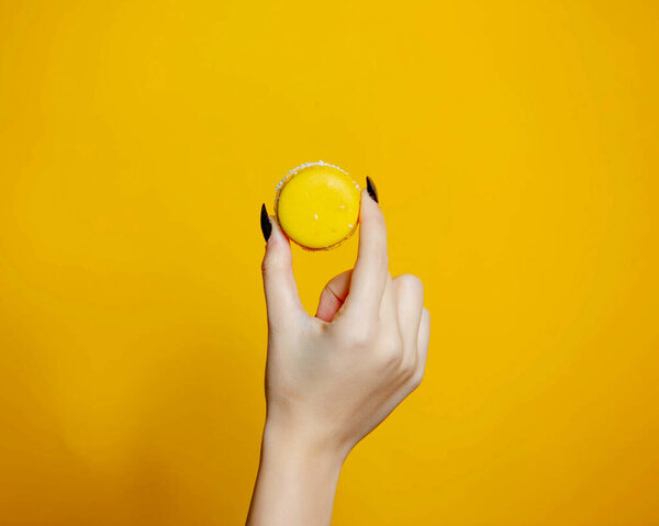 a person holding yellow cookie