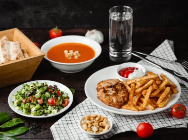 Domates çorbası, sebze salatası ve patates kızartmalı tavuk.