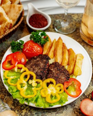 Kızarmış patates ve sebzeli et pirzolası.