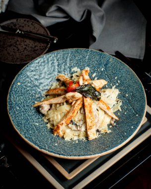 Izgara tavuk fileto ile süslenmiş mantar alfredo fettuccine.