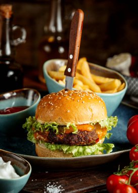 İçinde bıçak ve patates kızartmasıyla servis edilen çizburger.