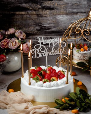 Çilekli doğum günü pastası altın mumlar ve mutlu yıllar standı
