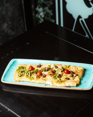 Üstüne mantar ve domates konmuş güveç.