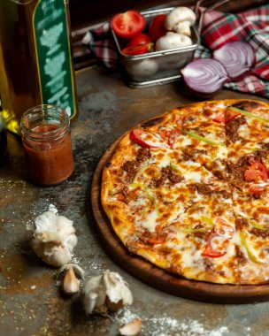 Domatesli, biberli ve peynirli etli etli pizzanın yarısı.