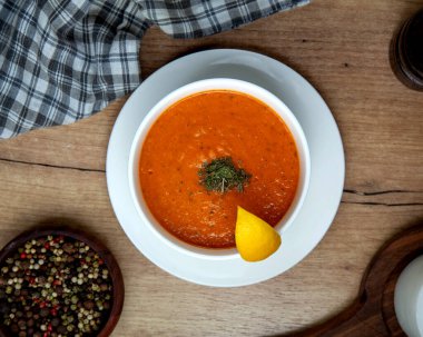 Kurutulmuş nane ve limon dilimiyle süslenmiş mercimek çorbası manzarası.