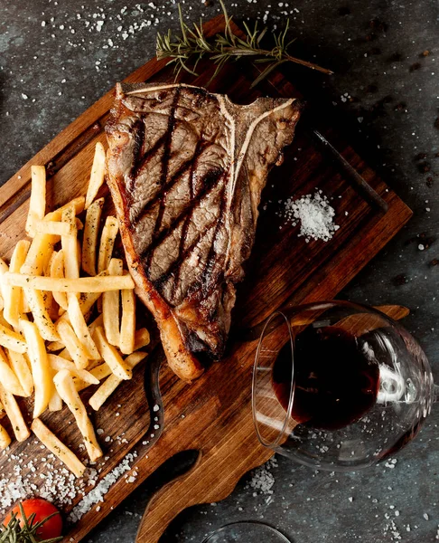 木の板の上にフライドポテトと新鮮なおいしいステーキ — ストック写真