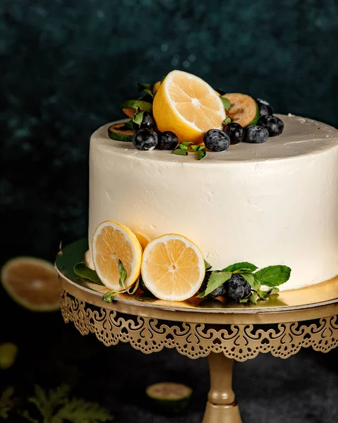 白いクリームとレモンで装飾された丸いケーキ — ストック写真