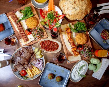 Akşam yemeği, et ve tavuk kebabı salata, ekmek ve kızarmış patates kızartması.