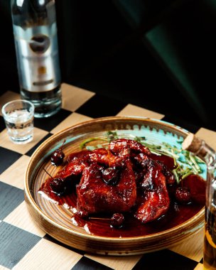 Yanında ızgara vişne soslu tavuk ve masada votka.