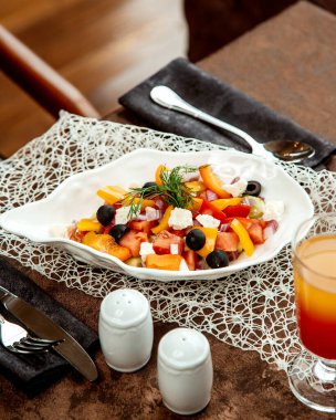 Bir tabak sebze salatası, domates dolma biber, zeytin kırmızısı soğan, salatalık ve beyaz peynir.