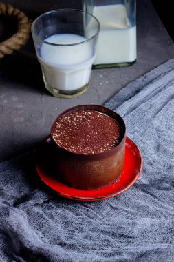 Bir bardak sütle servis edilen kakao tozlu tatlı.