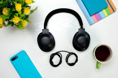 kablosuz kulaklıklar akıllı telefon ve bir fincan kahve.