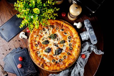 Mantar, zeytin ve fesleğen yapraklı pizza.