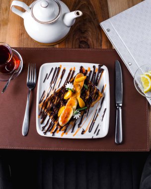 Muz dilimli Belçika waffle 'ı, krema ve çayla servis edilen çikolata.