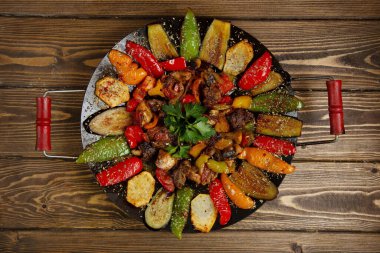 meat sage with potatoes bell pepper and eggplant cooked on charcoal top view clipart