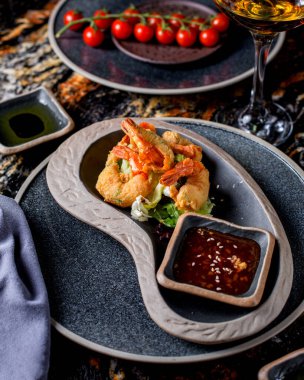 Marul ve sosla servis edilen kızarmış karidesler.