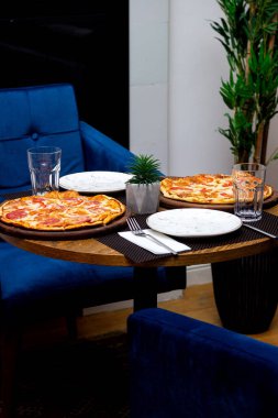 Yuvarlak masada sosisli çıtır pizza.