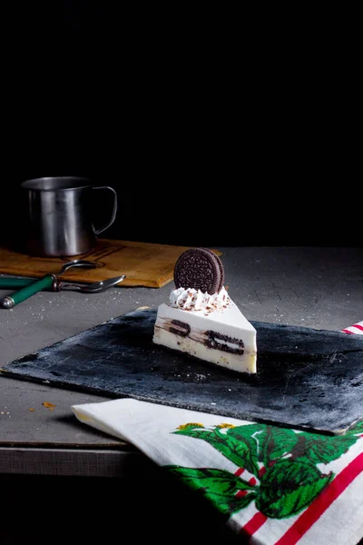 オレオ クッキーとホワイトクリームで飾られたオレオ チーズケーキのスライス — ストック写真