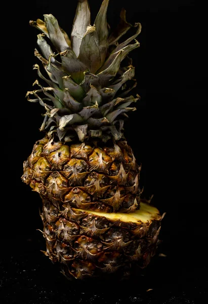 pineapple cut in half on a black background