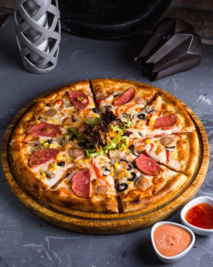 Salamlı pizza masada.