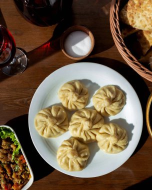 Üst görünüm khinkali et salatası, ekmek gübresi ve masada tuz.