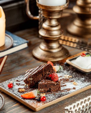 Çikolata şurubu ve şeker tozuyla süslenmiş cevizli kek dilimleri.