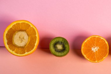 Yarısı dilimlenmiş portakallı limon ve kivi masada.