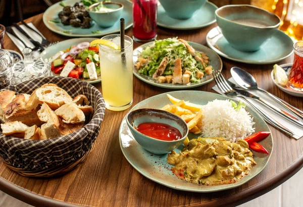 Tavuklu akşam yemeği, pilav, patates kızartması sezar, sebze salatası ve limonata ile servis edilir.