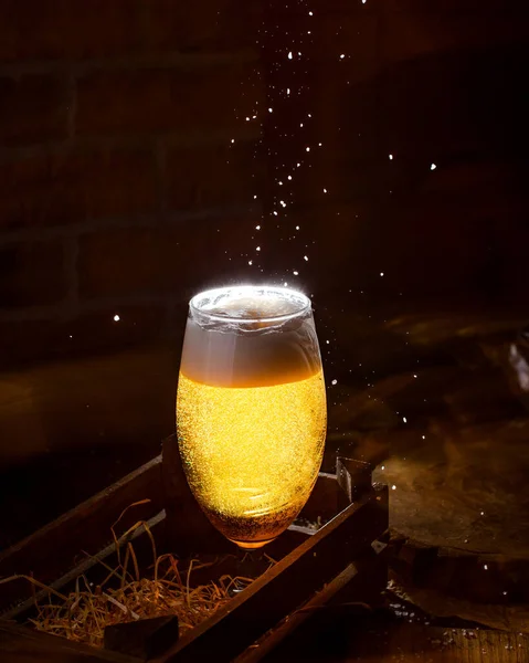 glass of beer with foam in the wooden box