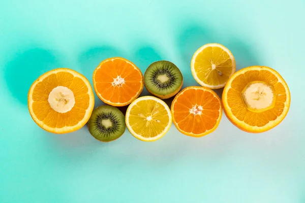 halves of oranges   kiwi and lemons on a blue table