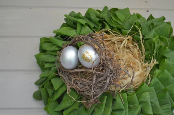 Yuvasında gümüş yumurtalar olan yeşil yapraklı bir çelenk. Paskalya bitkileri — Stok fotoğraf