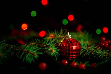 Noel oyuncakları, üzerinde yeşil Noel ağacı olan karanlık arka planda ışıklar