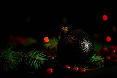 Noel oyuncakları, üzerinde yeşil Noel ağacı olan karanlık arka planda ışıklar