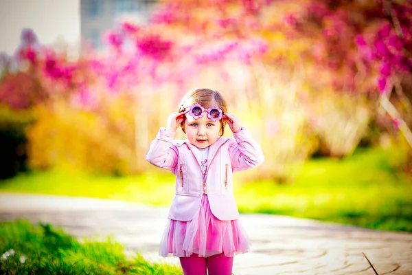 Malá Krásná Dívka Růžových Šatech Slunečních Brýlích Procházka Parku — Stock fotografie