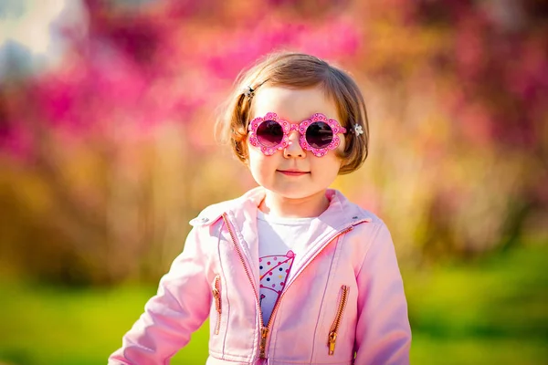 Pembe Elbiseli Güneş Gözlüklü Parkta Yürüyen Küçük Güzel Bir Kız — Stok fotoğraf
