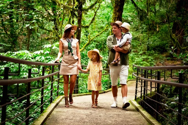 Mutlu, genç bir aile, yaz aylarında bir Safari Parkı 'nda şık kıyafetler ve şapkayla geziyor.