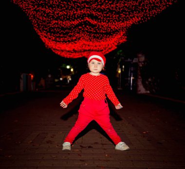 Kırmızı elbiseli ve şapkalı küçük, havalı bir kız..