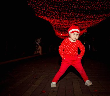 Kırmızı elbiseli ve şapkalı küçük, havalı bir kız..