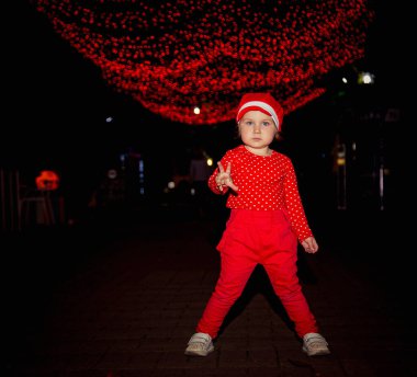 Kırmızı elbiseli ve şapkalı küçük, havalı bir kız..