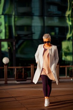 Genç, mutlu kadın güneş gözlüğü takıyor.