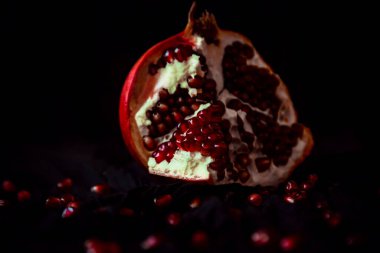 Koyu arkaplanda olgun, sulu bir nar.