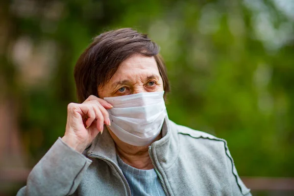 an adult woman, a pensioner, on a walk in a medical mask